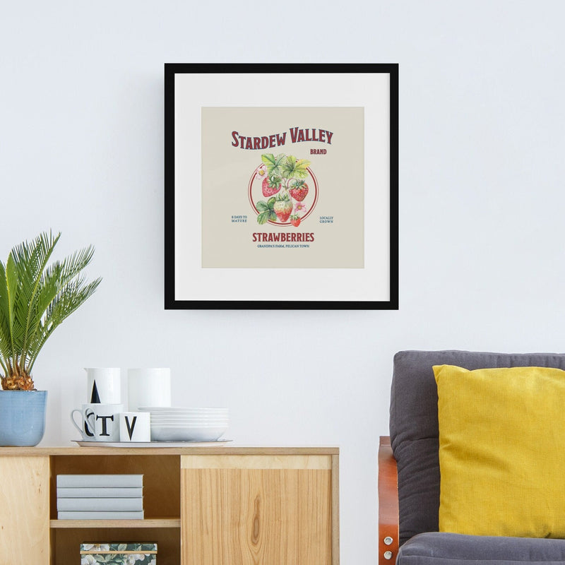 A large Stardew Valley Strawberries Print by New Save in a black frame on a living room wall.